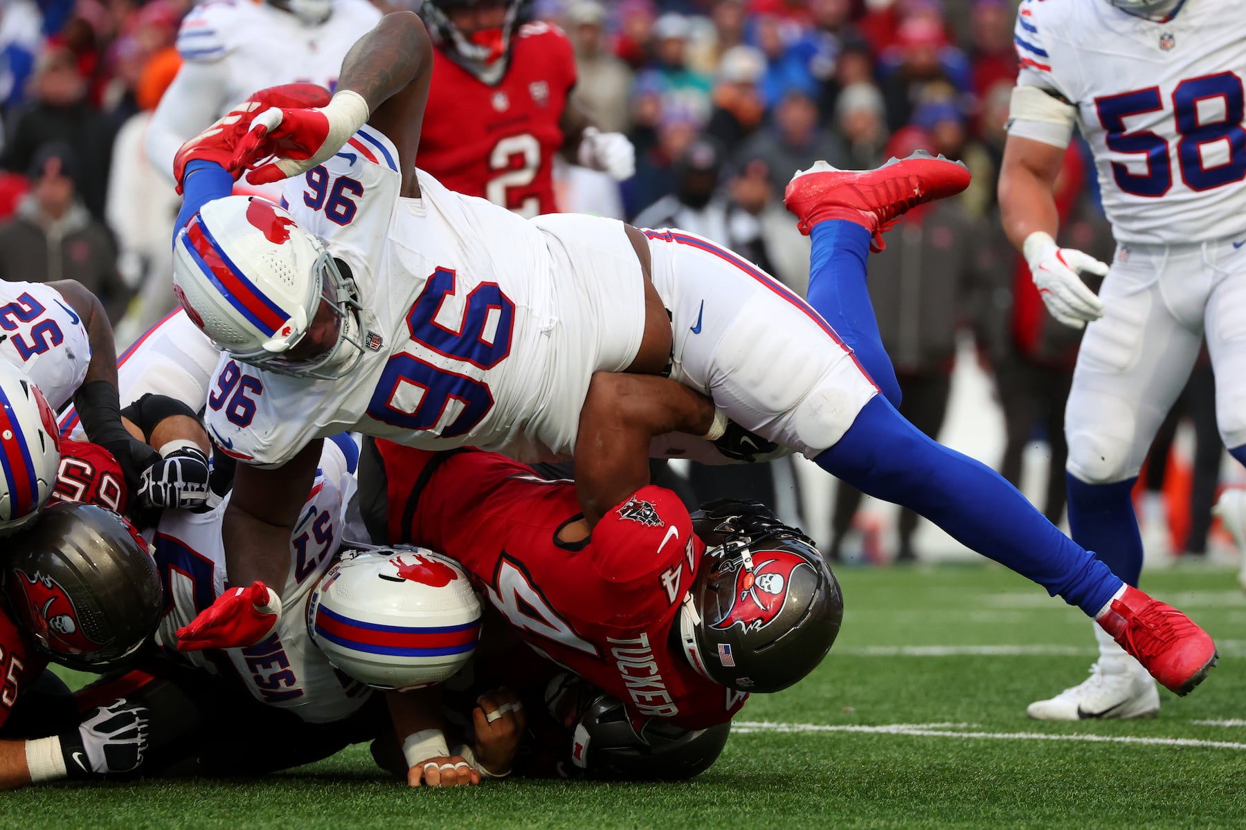 Buffalo Bills defensive tackle Deone Walker (96) tackles Tampa Bay Buccaneers running back Sean Tucker, bottom right, during the second half of an NFL football game, Sunday, Nov. 16, 2025, in Orchard Park, N.Y. (AP Photo/Jeffrey T. Barnes)