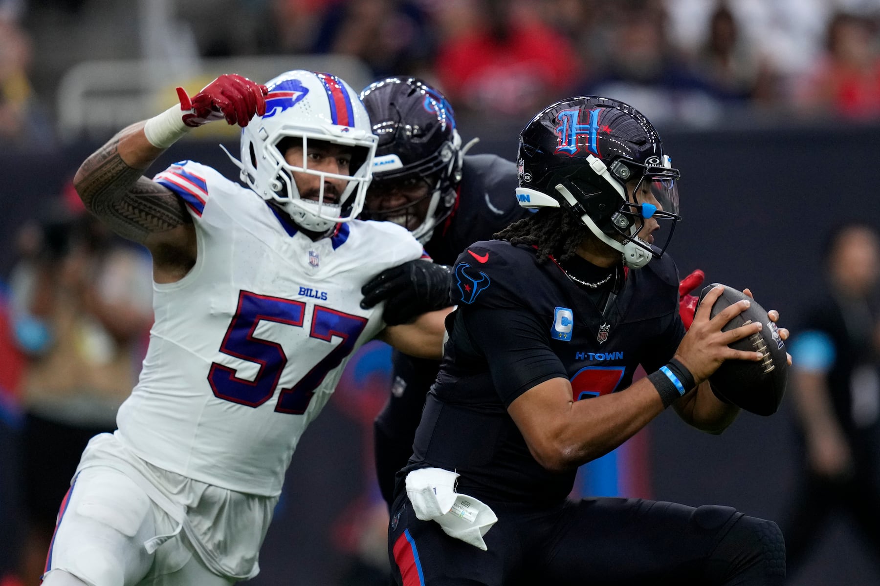 Houston Texans quarterback C.J. Stroud runs from Buffalo Bills defensive end AJ Epenesa (57) during the first half of an NFL football game, Sunday, Oct. 6, 2024, in Houston. (AP Photo/Eric Gay)