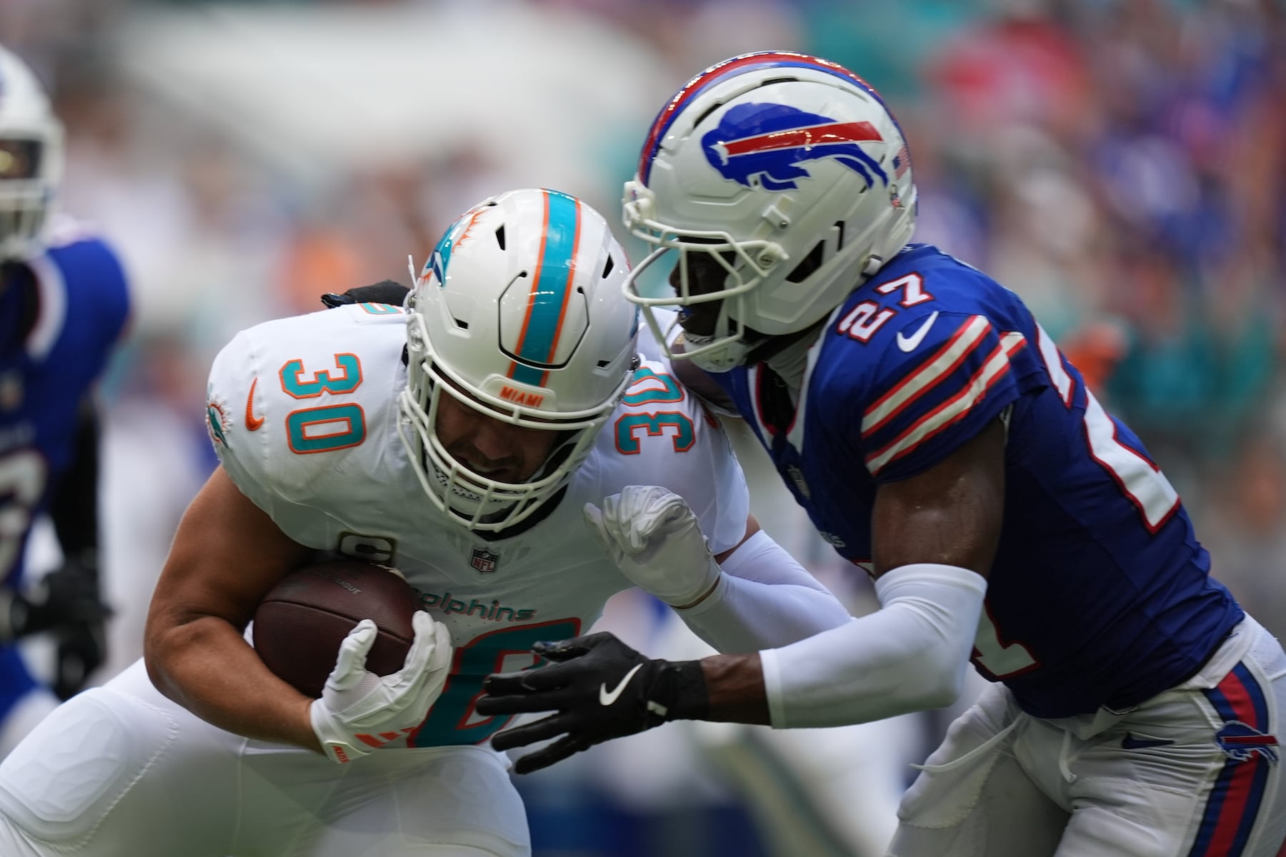 Miami Dolphins' Alec Ingold (30) is tackled by Buffalo Bills' Tre'Davious White (27) during the first half of an NFL football game, Sunday, Nov. 9, 2025, in Miami Gardens, Fla. (AP Photo/Rebecca Blackwell)