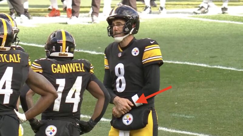 Aaron Rodgers grabs his left wrist in pain