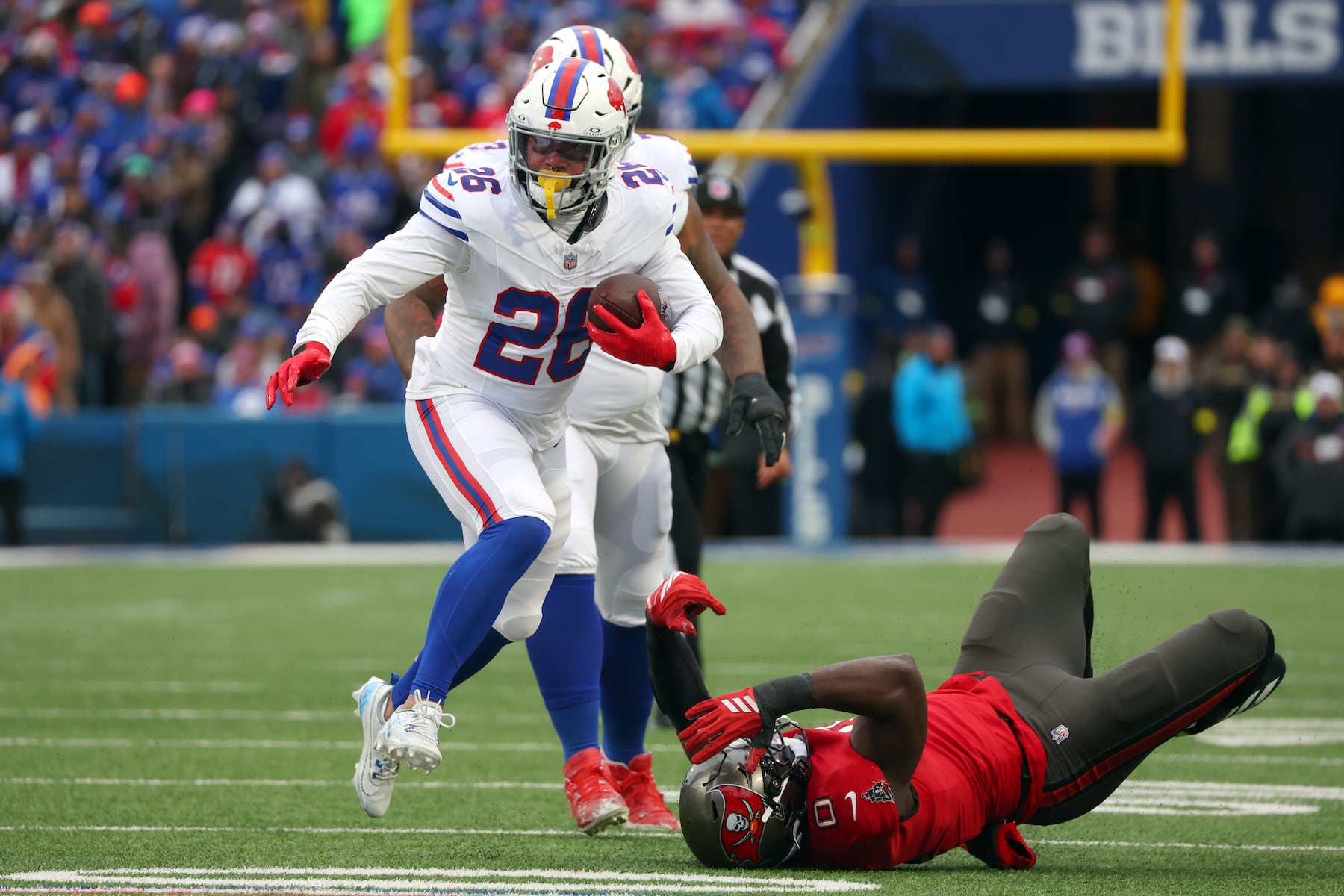 Buffalo Bills running back Ty Johnson (26) runs against Tampa Bay Buccaneers linebacker Yaya Diaby (0) during the first half of an NFL football game, Sunday, Nov. 16, 2025, in Orchard Park, N.Y. (AP Photo/Jeffrey T. Barnes)