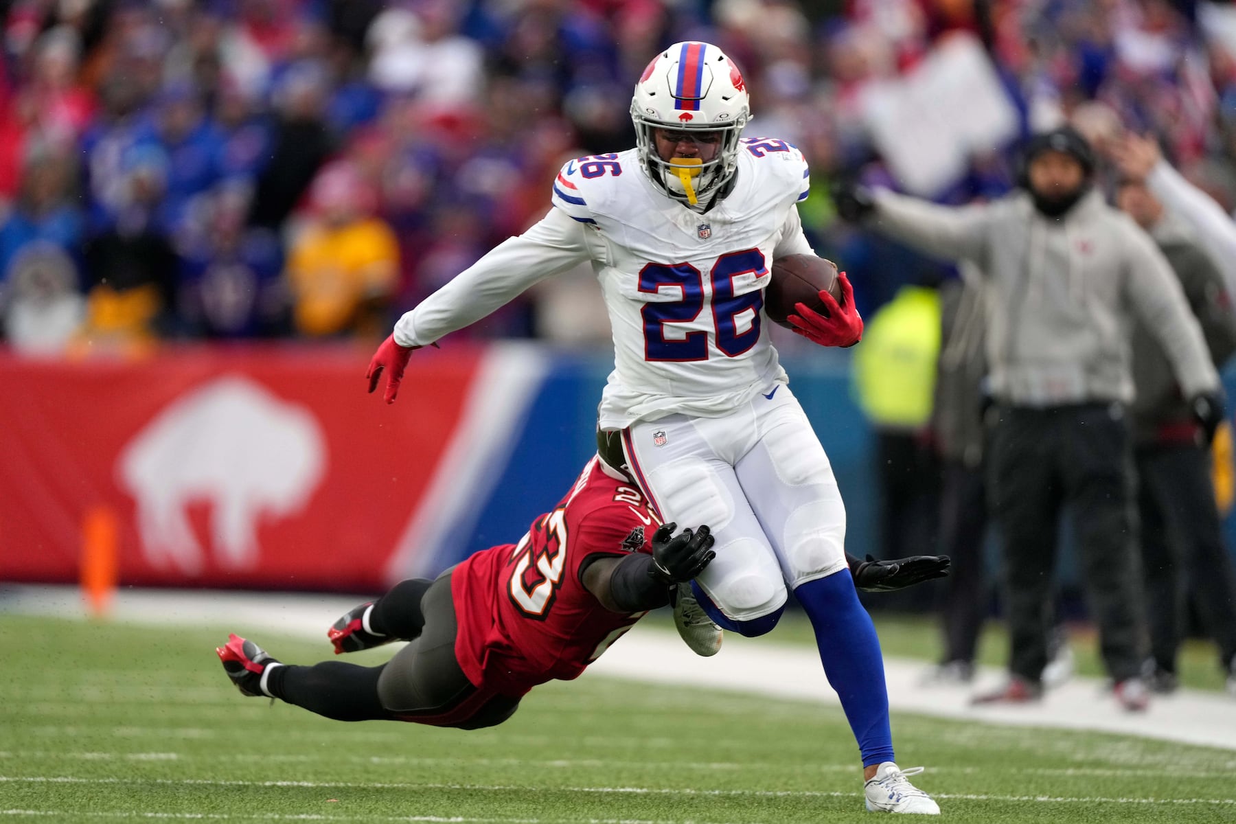Buffalo Bills running back Ty Johnson (26) runs against Tampa Bay Buccaneers safety Tykee Smith (23) during the first half of an NFL football game, Sunday, Nov. 16, 2025, in Orchard Park, N.Y. (AP Photo/Carolyn Kaster)