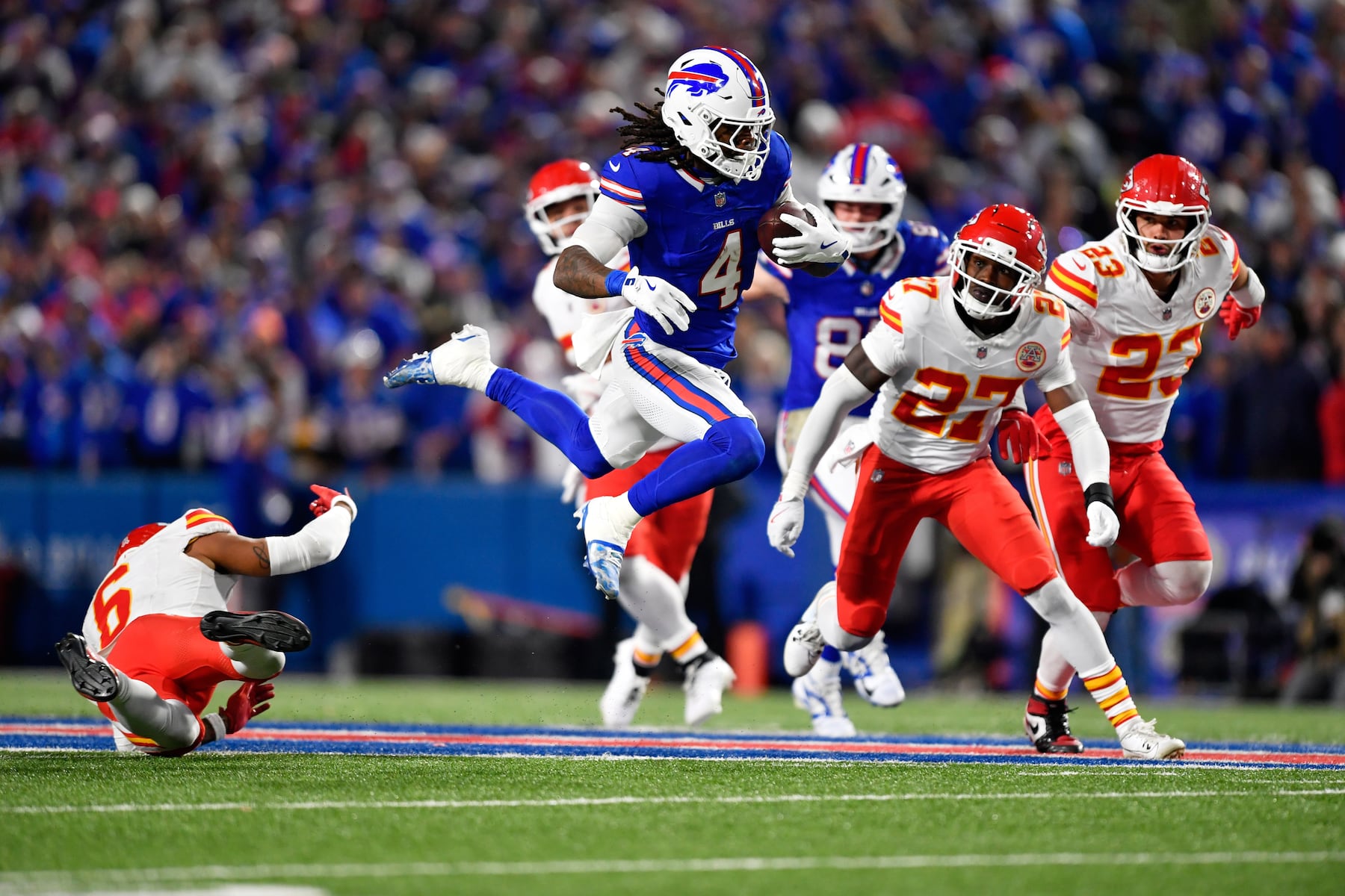 Buffalo Bills running back James Cook III (4) runs with the ball as Kansas City Chiefs safety Bryan Cook (6), defensive back Chamarri Conner (27) and Drue Tranquill (23) defend during the first half of an NFL football game Sunday, Nov. 2, 2025, in Orchard Park. N.Y. (AP Photo/Adrian Kraus)