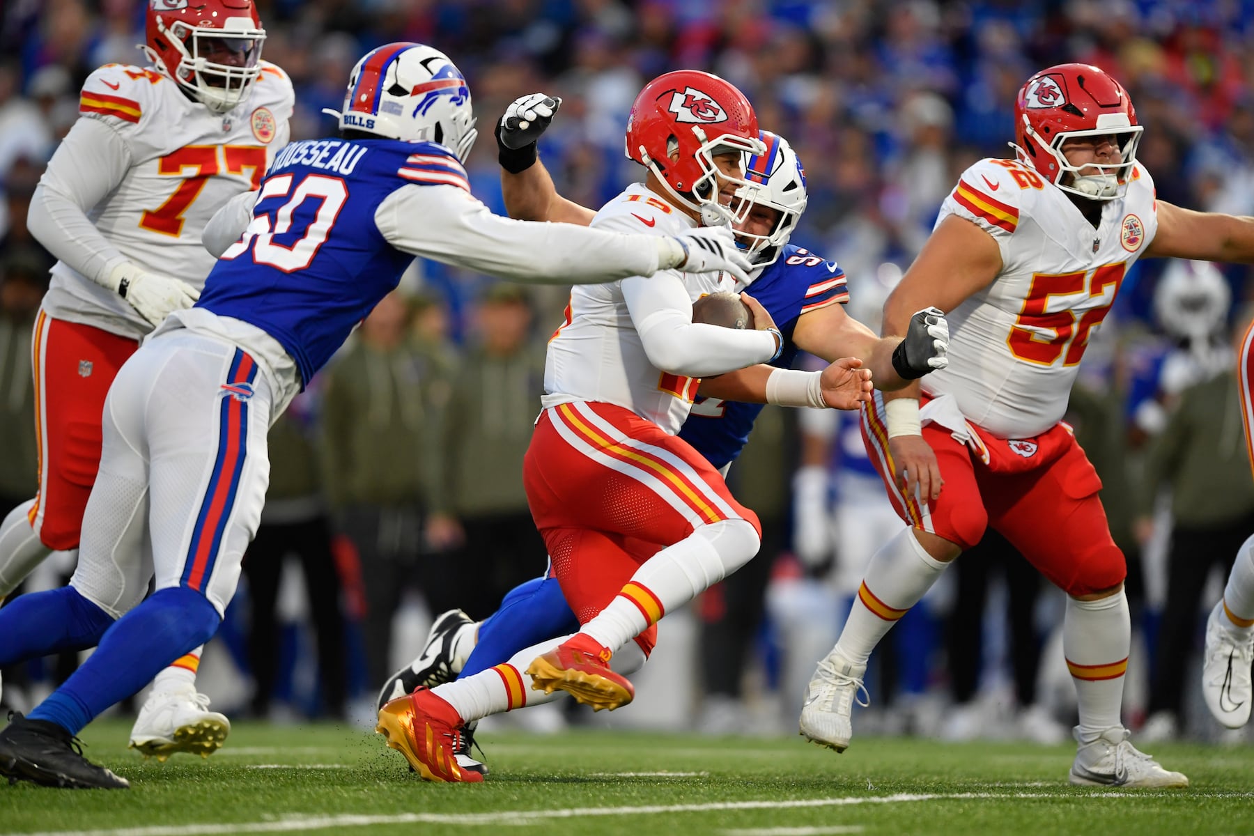 Kansas City Chiefs quarterback Patrick Mahomes (15) scrambles for a first down as Buffalo Bills defensive end Greg Rousseau (50) defends during the first half of an NFL football game Sunday, Nov. 2, 2025, in Orchard Park. N.Y. (AP Photo/Adrian Kraus)