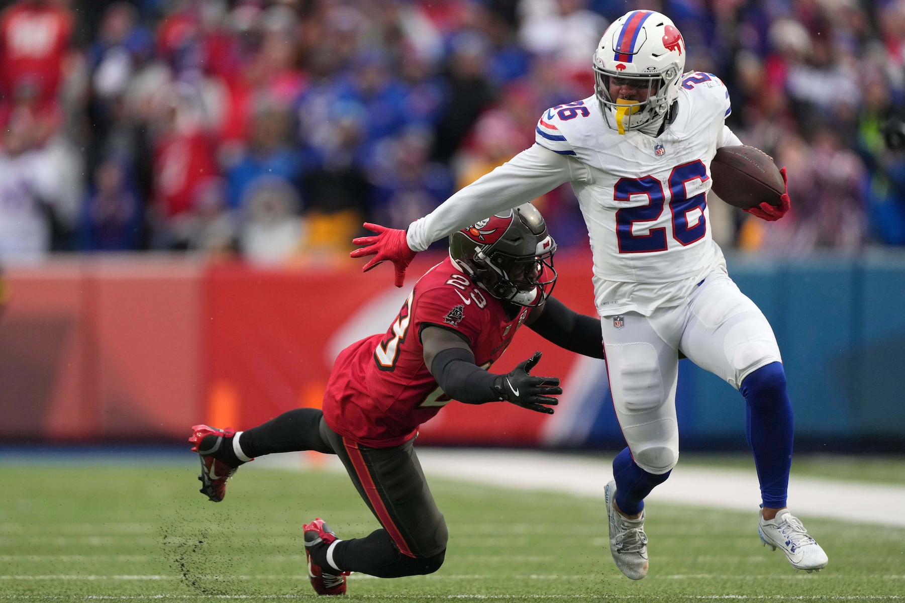 Buffalo Bills running back Ty Johnson (26) runs against Tampa Bay Buccaneers safety Tykee Smith (23) during the first half of an NFL football game, Sunday, Nov. 16, 2025, in Orchard Park, N.Y. (AP Photo/Carolyn Kaster)