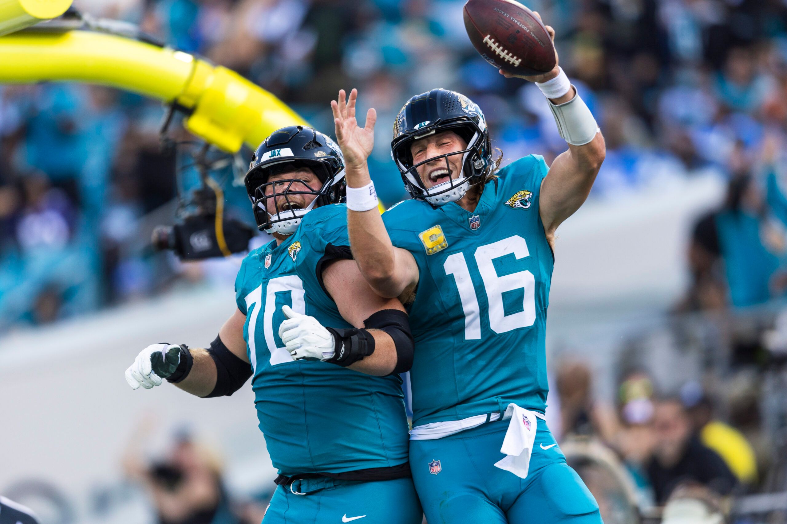 Jacksonville Jaguars quarterback Trevor Lawrence (16) celebrates with offensive tackle Cole Van Lanen (70) after rushing for a touchdown against the Los Angeles Chargers during the third quarter at EverBank Stadium.