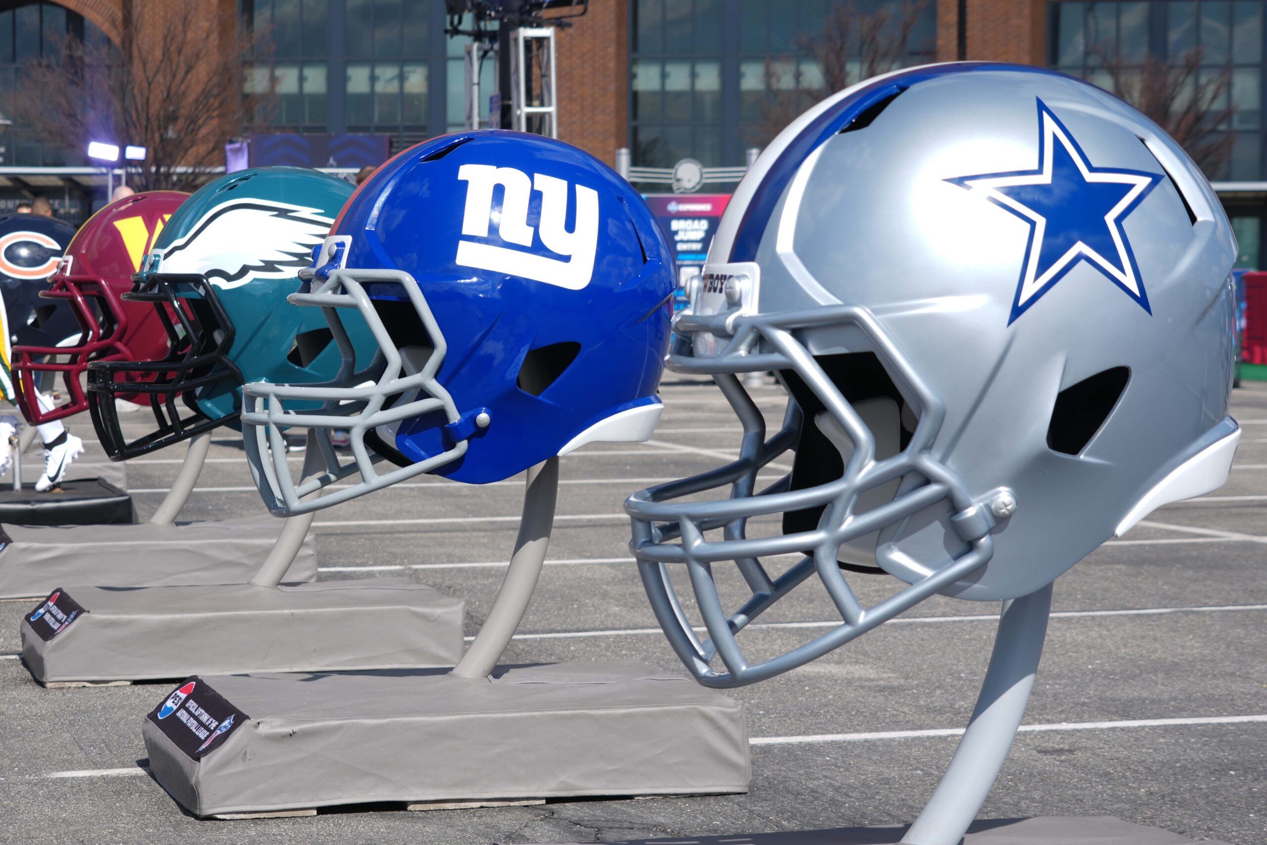 NFC East helmets of the Dallas Cowboys, New York Giants, Philadelphia Eagles and Washington Commanders at the 2025 NFL Scouting Combine Experience at Lucas Oil Stadium.